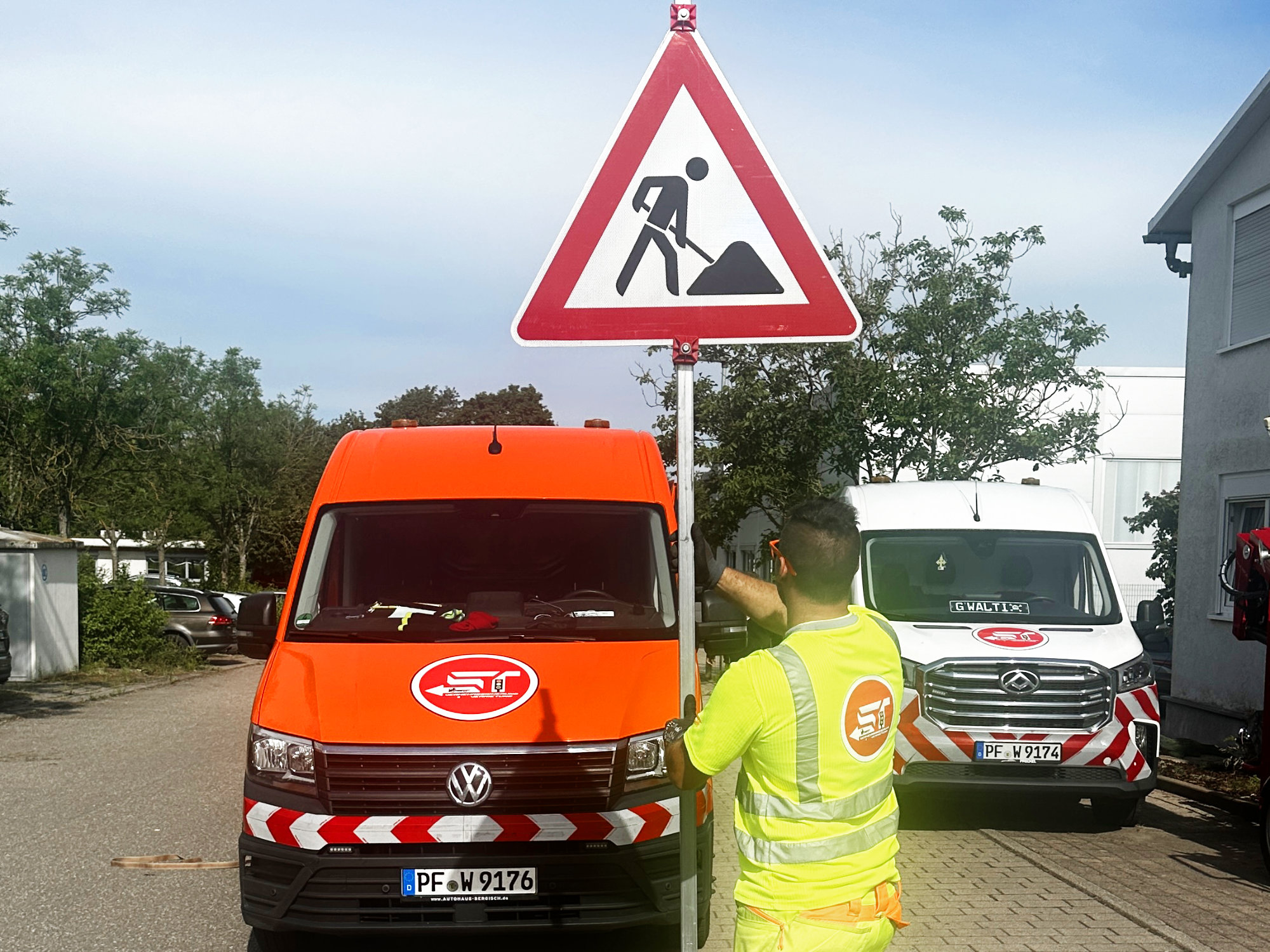 Mitarbeiter von ST Verkehrssicherung baut Straßenschild auf